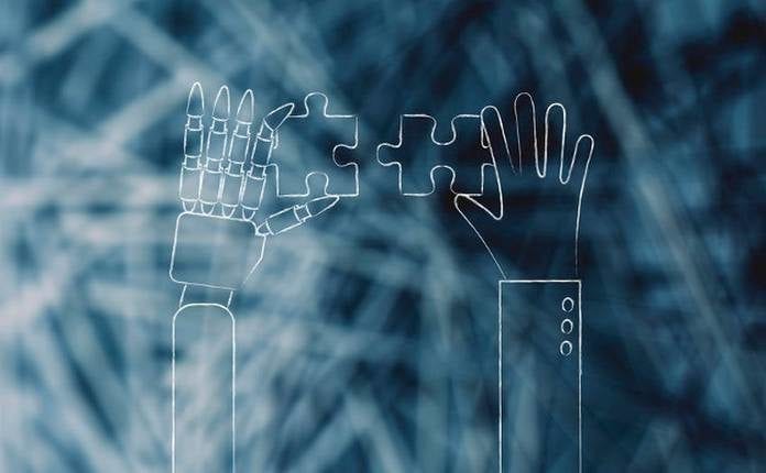 concept of artificial intelligence: human and robot hands solving a puzzle